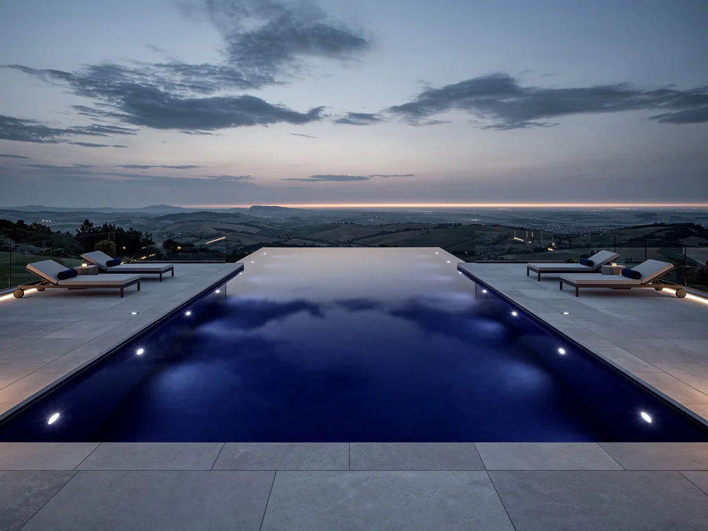 Liner bleu nuit posé dans une grande piscine à débordement